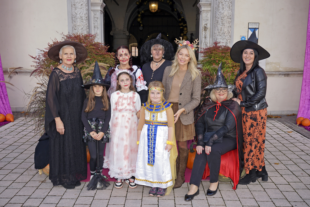 Kostümierte Kinder und Frauen verkleidet für Halloween vor einem Gebäude in Österreich.
