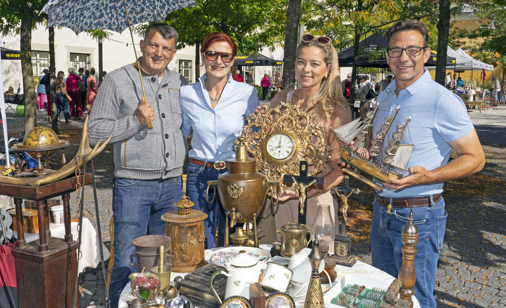 Vier Personen auf einem Flohmarkt in Österreich mit Antiquitäten